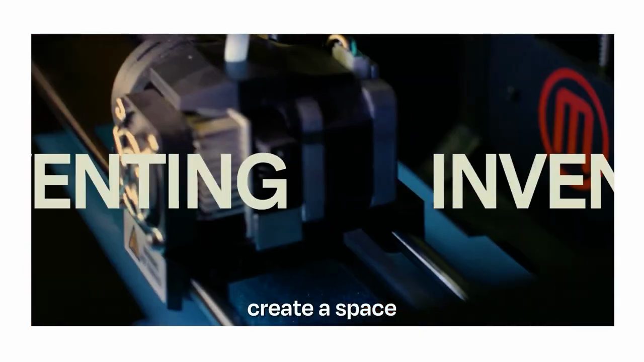 Cận cảnh đầu in của một máy in 3D, chữ lớn INVENTING chạy ngang khung hình
