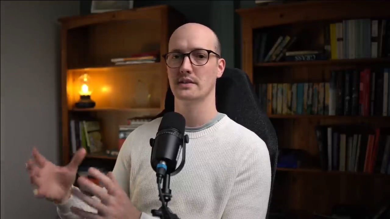 Matt Pocock nói trước micro trong phòng có giá sách