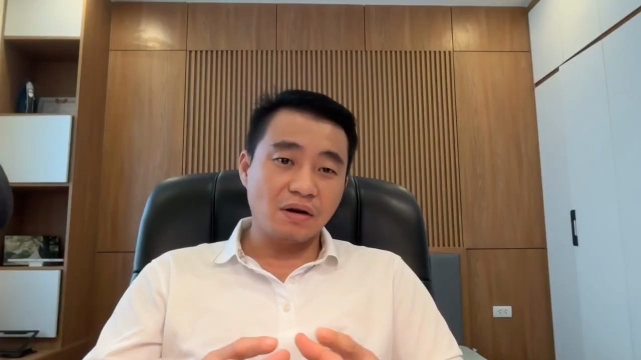 Trịnh Minh Hùng ngồi ghế da trong phòng làm việc ốp gỗ, nói trước camera