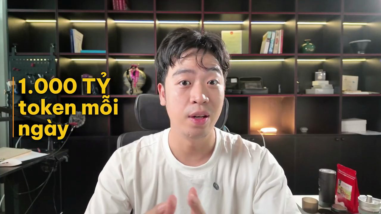 Thanh Trần nói trước kệ sách, chữ lớn trên hình ghi 1.000 tỷ token mỗi ngày