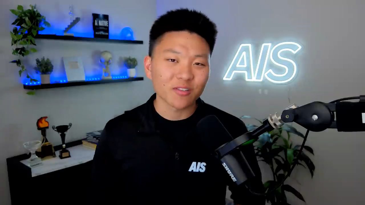 Nate Herk nói trước camera, phía sau là chữ AIS bằng đèn neon