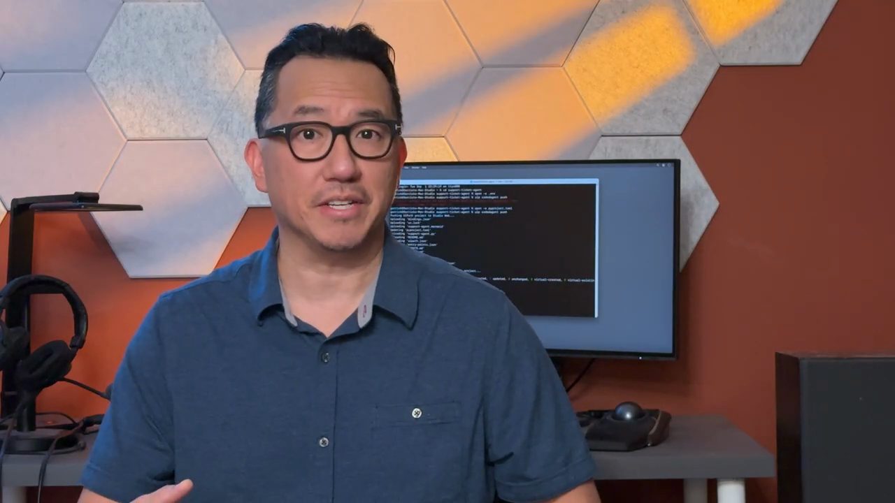 Garrick Chow nói trước camera, phía sau là màn hình terminal