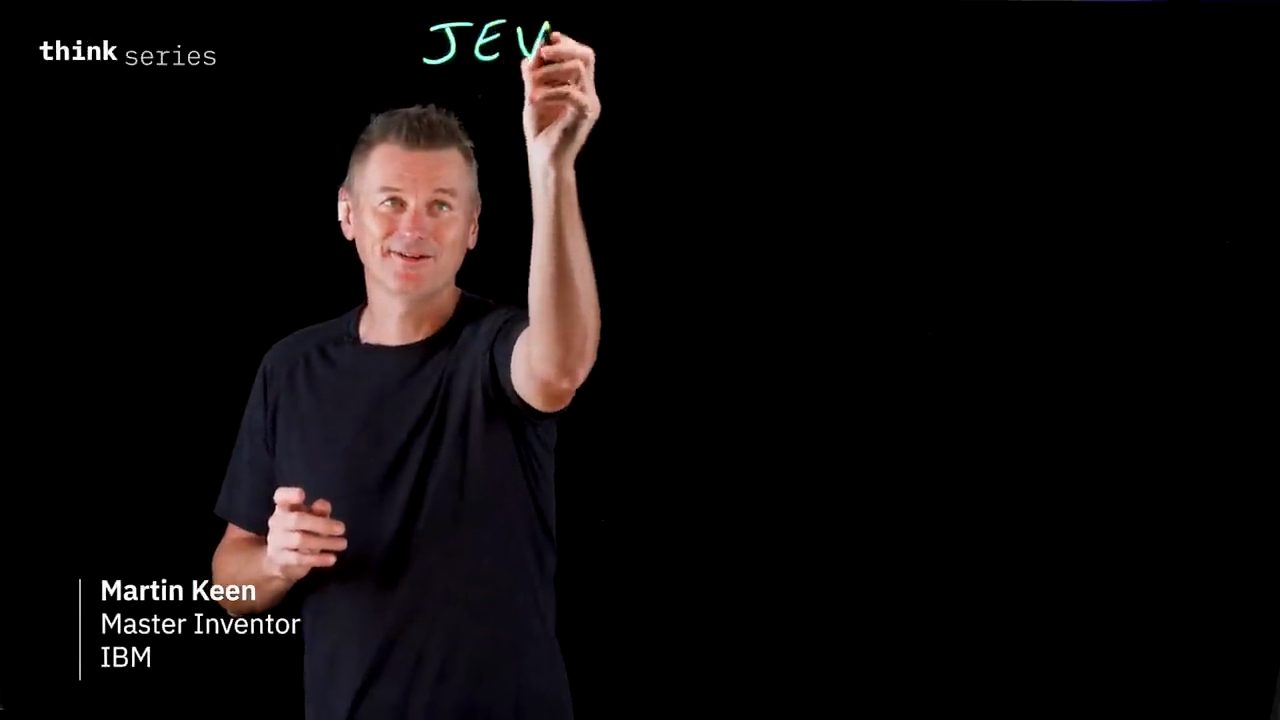 Martin Keen đứng trước lightboard đen, đang viết chữ JEV, góc dưới có dòng tên Martin Keen, Master Inventor, IBM