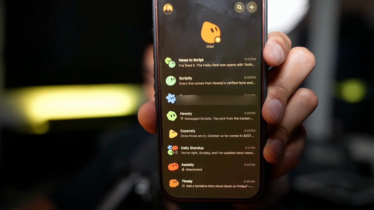 Sonny cầm điện thoại chạy app Grok Bot với Chief và danh sách các cuộc chat