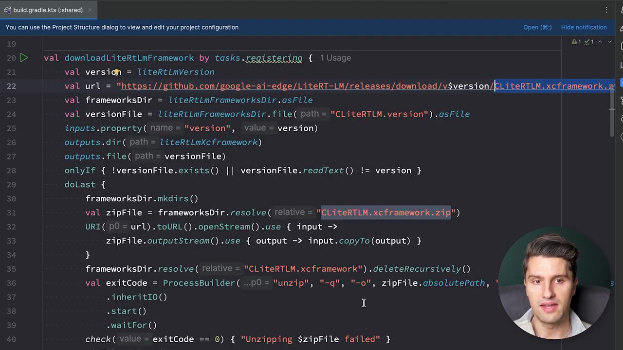 File build.gradle.kts với task downloadLiteRtLmFramework tải CLiteRTLM.xcframework.zip từ GitHub rồi unzip