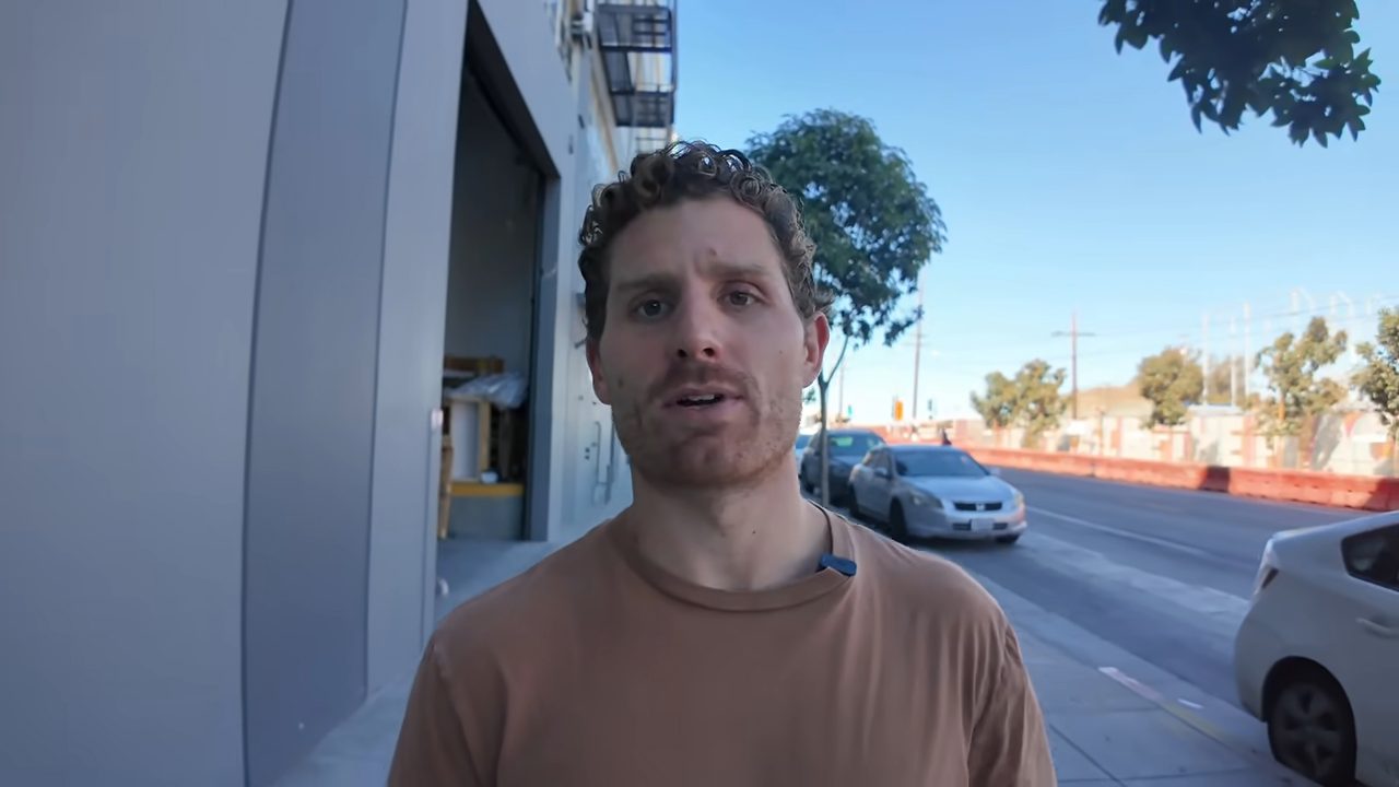 Matt Palmer nói trước camera khi đang đi trên vỉa hè